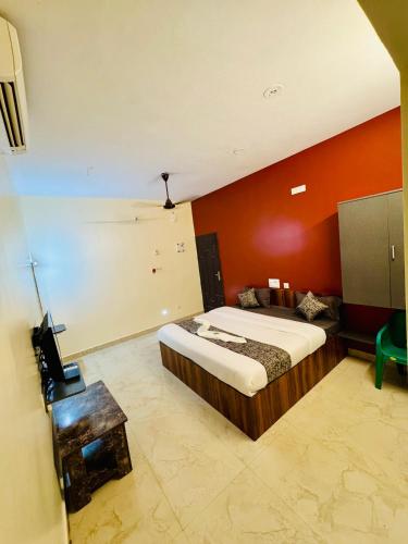 Un dormitorio con una cama y una pared naranja. en Olive By David Residency - Just 4 Kms from Meenakshi Amman Temple, en Madurai