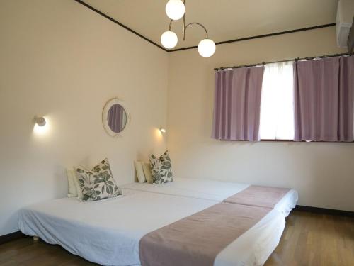 een slaapkamer met twee bedden en een raam bij ラフィーネハイツ 103 in Fuchu