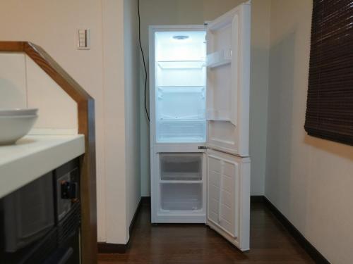 een lege koelkast met de deur open in een keuken bij ラフィーネハイツ 103 in Fuchu