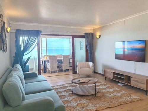 a living room with a couch and a flat screen tv at Ocean Blue Stay in St James