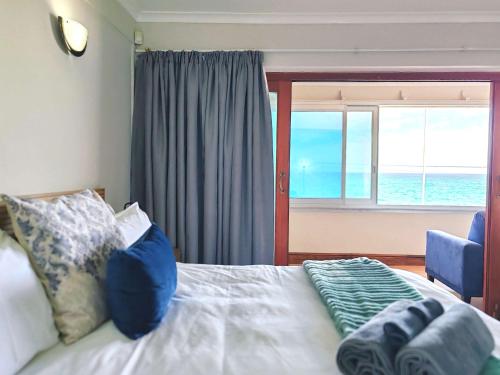 een slaapkamer met een bed met uitzicht op de oceaan bij Ocean Blue Stay in St James