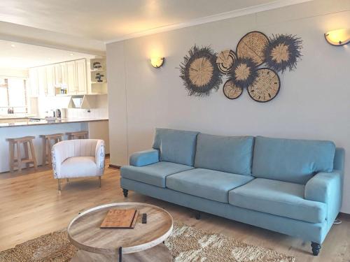 een woonkamer met een blauwe bank en een tafel bij Ocean Blue Stay in St James