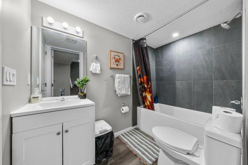 Un baño blanco con lavabo e inodoro. en Peaceful 1BHK - Maple, en Edmonton