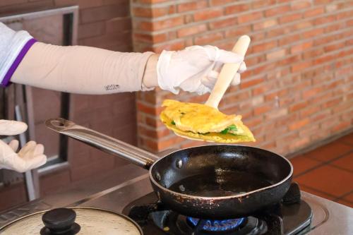 Uma pessoa está preparando um sanduíche em uma wok. em TTC Resort Ninh Thuan - Unlimited Access to Water Park em Phan Rang