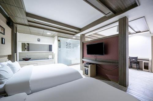 a bedroom with two beds and a flat screen tv at Jeonju Nabi in Jeonju