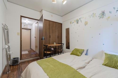 a bedroom with two beds and a table in it at 3 minutes walk from Minami Fukuoka Station, free Wi-Fi in Fukuoka