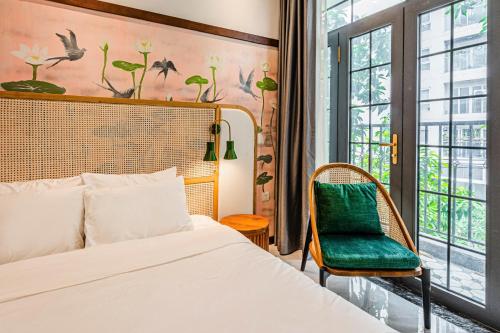 Misaki HCM Airport Hotel في مدينة هوشي منه: غرفة نوم بها سرير وكرسي ونافذة