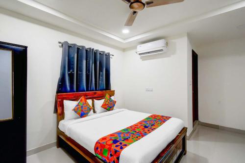 a bedroom with a bed with a blue curtain at FabHotel Aashvi in Hyderabad