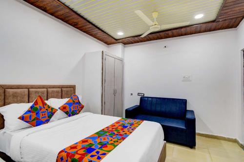 ハイデラバードにあるFabHotel Devara Grandのベッドルーム1室(ベッド1台、青い椅子付)