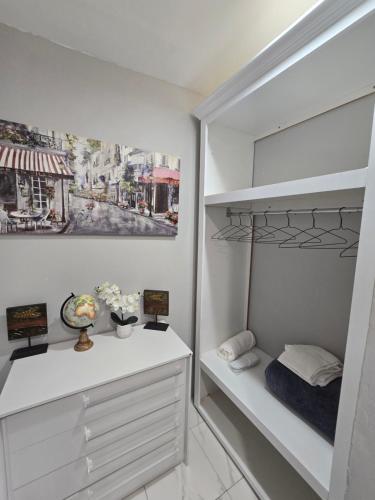 a white bedroom with a bed and a closet at El Rincón in Tunapuna