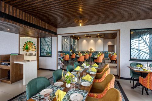 ハイデラバードにあるZIBE Luxe Hyderabad by GRT Hotelsの長いテーブルと椅子のあるダイニングルーム