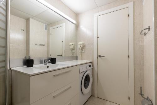 Un baño con lavabo y lavadora. en Michelangelo - PlanetCostaDorada, en Salou