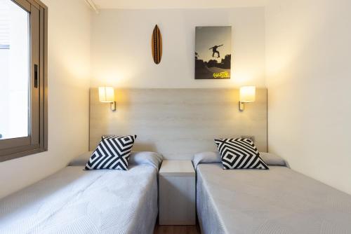 Dos camas una al lado de la otra en una habitación. en Michelangelo - PlanetCostaDorada, en Salou