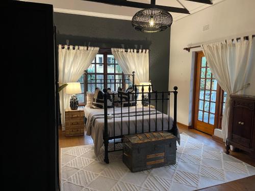 ein Schlafzimmer mit einem Bett und einem Kronleuchter in der Unterkunft Sandton Farmhouse in Johannesburg