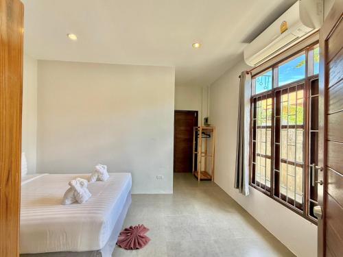 een slaapkamer met een bed en een groot raam bij Baan Suan Poolsap - Haad Rin Beach in Haad Rin