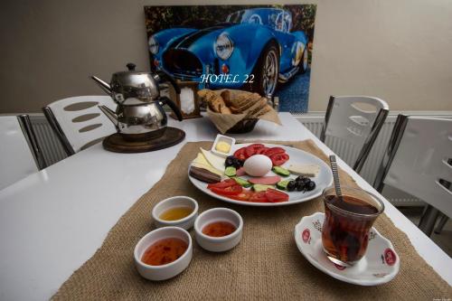 una mesa con un plato de comida y una taza de té en OTEL 22 EDiRNE, en Edirne