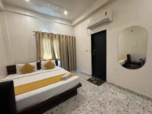 a bedroom with a large bed and a mirror at Hotel Vrinda Sarovar in Mathura