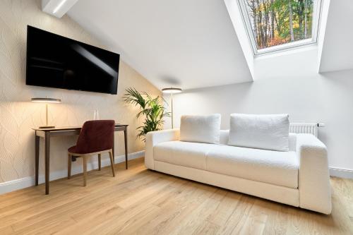 a living room with a white couch and a table at Villa Patriot Boutique Hotel in Mariánské Lázně