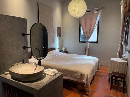 een slaapkamer met een bed met een wastafel en een spiegel bij Not just Tea Space in Quanzhou
