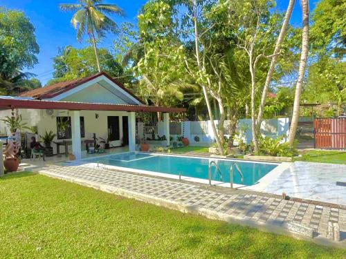 a villa with a swimming pool in front of a house at Double W Grand Villa Madiha in Matara