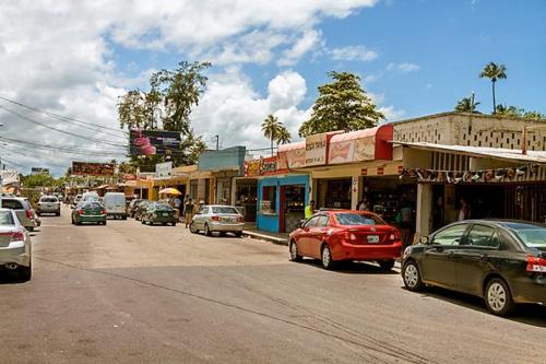 a busy city street with cars parked on the road at The Sandy Pearl Apartment in Luquillo
