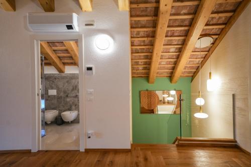 a bathroom with green walls and wooden ceilings at Alla Rocca Storica in Cavallino-Treporti