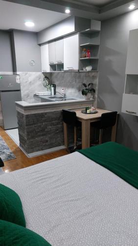 a kitchen with a sink and a table with chairs at Apartman Hram Zvornik in Zvornik