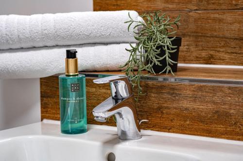 a bathroom sink with a green soap bottle on it at Apartment im Stadtzentrum von Riesa in Riesa