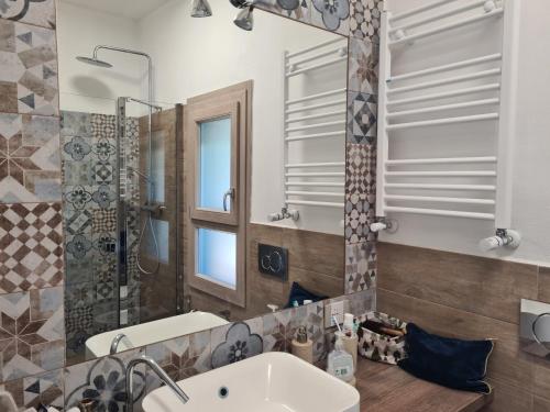 a bathroom with a sink and a mirror at Portion of a villa with a private pool in Ansedónia