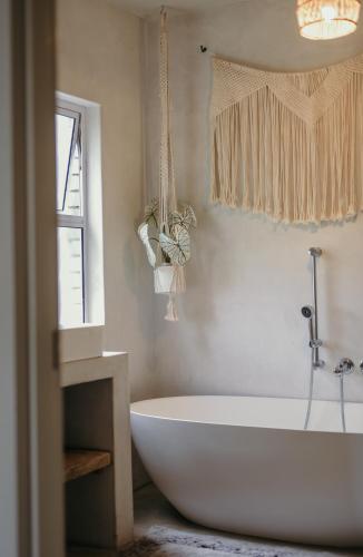 a white bath tub in a bathroom with a window at Clanwilliam Dam House in Clanwilliam