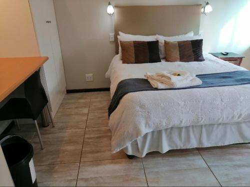 een slaapkamer met een bed met handdoeken erop bij Twilight Inn in Vryheid