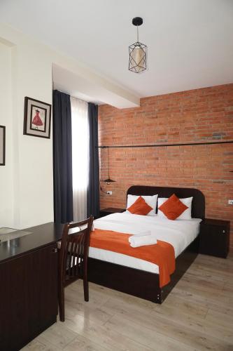 a bedroom with a bed and a desk and a bed sidx sidx sidx at Hotel New Terrace in Tbilisi City