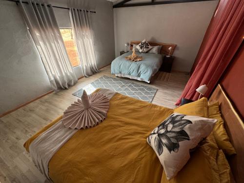a bedroom with a large bed with pillows on it at Big Cats Namibia Farmstays in Outjo
