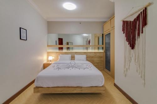 a bedroom with a white bed in a room at 2BR Apartment Majesty W Pool in Bandung