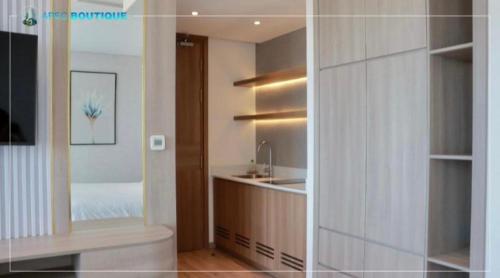 a bathroom with a sink and a kitchen with a mirror at Mandala Wins Hotel Phú Yên in Phước Hậu
