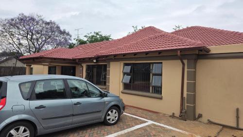 a small car parked in front of a house at Ntale Guest House in Benoni
