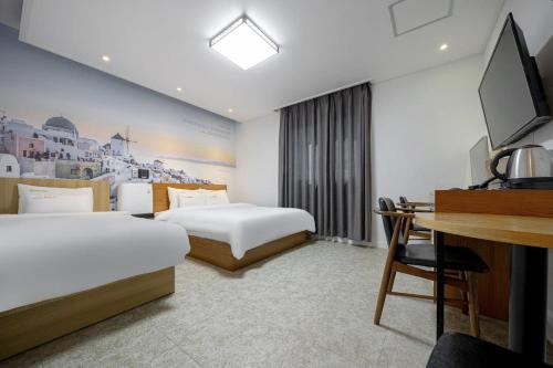 全州市にあるJeonju Raon Hotelのベッド2台と机があるホテルの部屋