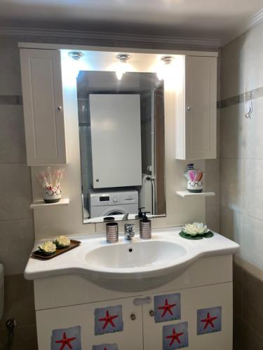 a bathroom with a sink and a mirror at Maria Cozy Getaway in Glyfada in Athens