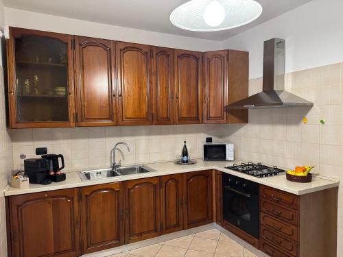 Una cocina con gabinetes de madera y un horno de estufa. en B&B Silvy, en Pero