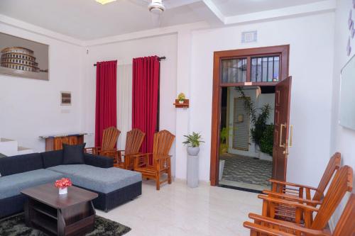 - un salon avec un canapé bleu et des fauteuils en bois dans l'établissement Aru Villa Galle, à Galle