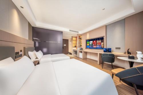 een hotelkamer met een bed en een televisie bij Jingyue Yaduo Hotel in Yiwu