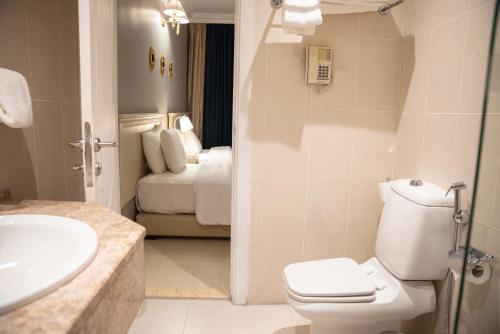 1 dormitorio y baño con aseo y lavamanos. en Amman West Luxury Hotel By Azar, en Amán