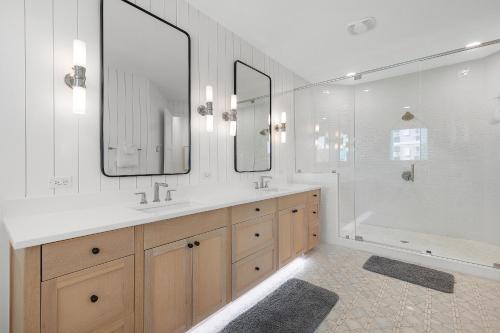 a bathroom with two sinks and a tub and mirrors at Sea View Play in New Smyrna Beach