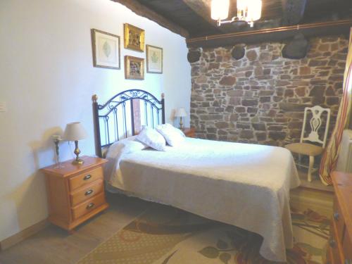 une chambre avec un lit et un mur en pierre dans l'établissement Luna Menguante, à La Viliella