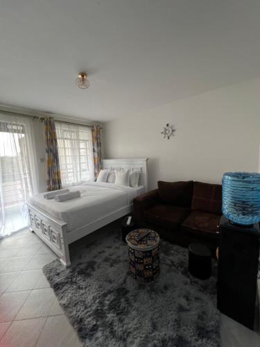 un salon avec un lit et un canapé dans l'établissement Anakwa Villas, à Nairobi
