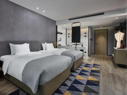 een hotelkamer met twee bedden en een flatscreen-tv bij Ningbo Wanda Moments Hotel in Ningbo