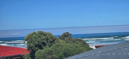Una vista de la playa y el océano desde un edificio. en Coastal Bliss Steps from Beach, en Cape Town