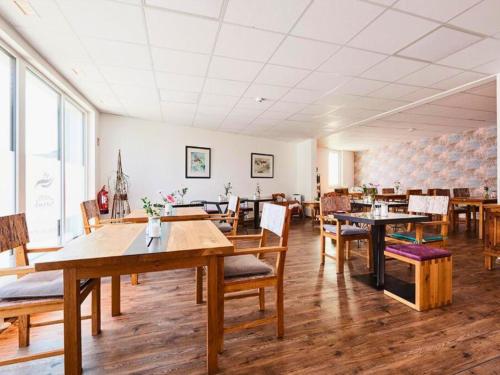 a dining room with wooden tables and chairs at Hotel Sarah in Heinsberg