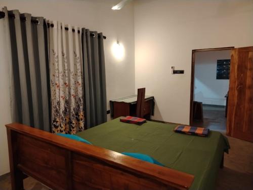 1 dormitorio con cama verde y espejo en Mirissa Surf Villa, en Mirissa