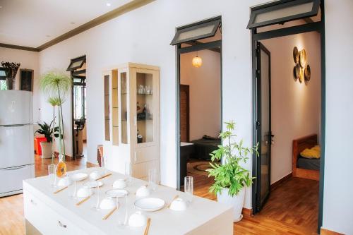 una habitación con una mesa blanca con platos. en Villa Hồng Phúc, en Ấp Thiện Lập
